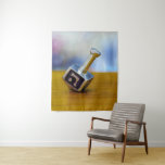 SlipperyJoe's Hanukkah traditional toy gifts close Tapestry<br><div class="desc">SlipperyJoe's Hanukkah traditional toy gifts close-up metallic dreidel resting visible etched Hebrew letter Shin ש Nes Gadol Haya Sham great miracle happened there artistic festive blurred Bokeh background tradition storytelling small rituals themes warm organic grain wooden surface backdrop glows soft colourful lights four-sided silver metal spinning top reds greens yellows...</div>