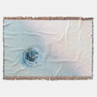 Slow motion wave towards a blue seashell throw blanket