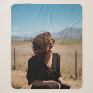 Smiling woman on brown and green field sherpa blanket