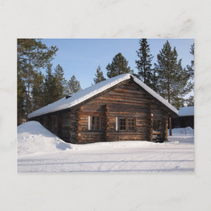 Snow-covered log cabin in Lapland postcard