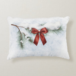 snow-covered pine branch with a festive red bow decorative cushion