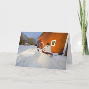 Snowman in front of red barn in Columbia Falls Holiday Card