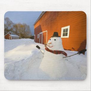 Snowman in front of red barn in Columbia Falls Mouse Mat