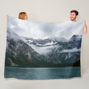 Snowy mountains in the fog at Plansee lake Fleece Blanket