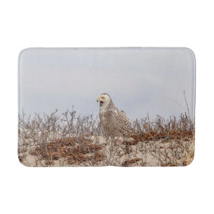 Snowy owl sitting on the beach bath mat