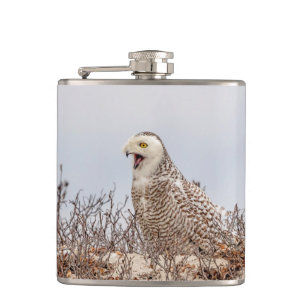 Snowy owl sitting on the beach hip flask