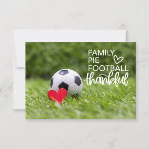 Soccer ball with red heart on green grass thank you card