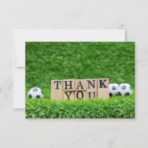 Soccer ball with word Thank you on green grass