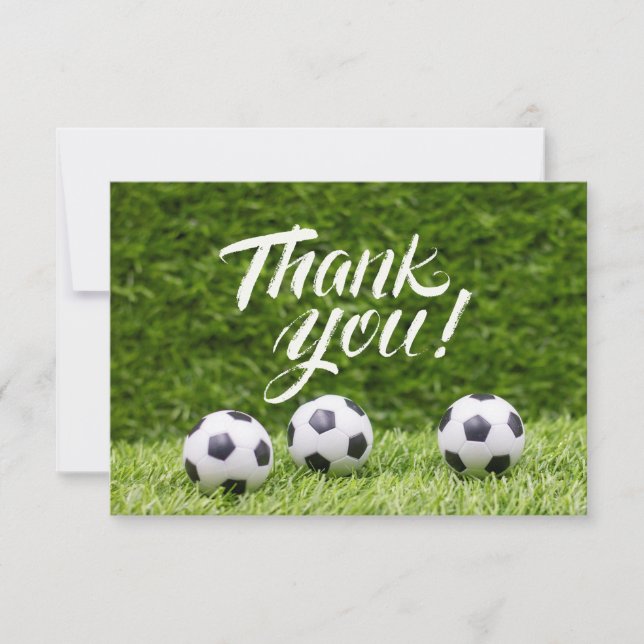 Soccer ball with word Thank you on green grass (Front)