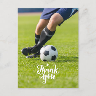 Soccer ball with word Thank you on green grass Postcard