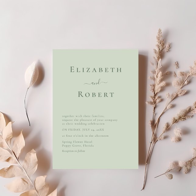 Soft Sage Green Modern Minimalist Script Wedding Invitation (Soft Sage Green Modern Minimalist Script Wedding Invitation on a table with blush pink flowers.)