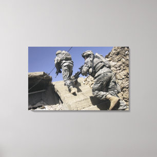 Soldiers running up staircase of a building canvas print