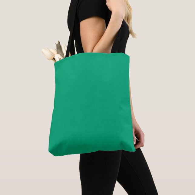 Solid teal background with a smooth texture tote bag (Close Up)