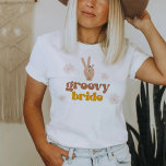 SONNY Groovy Bride Retro 70's Hippie Bachelorette  T-Shirt<br><div class="desc">This Groovy Bride bachelorette t shirt features boho daisies florals, a pace hand sign and a groovy retro themed font and colour combination. This t shirt is perfect as a group gift for a bachelorette weekend. Grab the matching "Groovy babe" Shirt for a cohesive look. 💜 COLORS ARE EDITABLE! Click...</div>