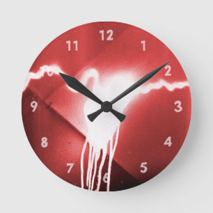 Sprayed graffiti on red metal round clock