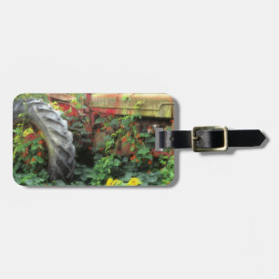 Spring flowers adorn an old tractor. luggage tag