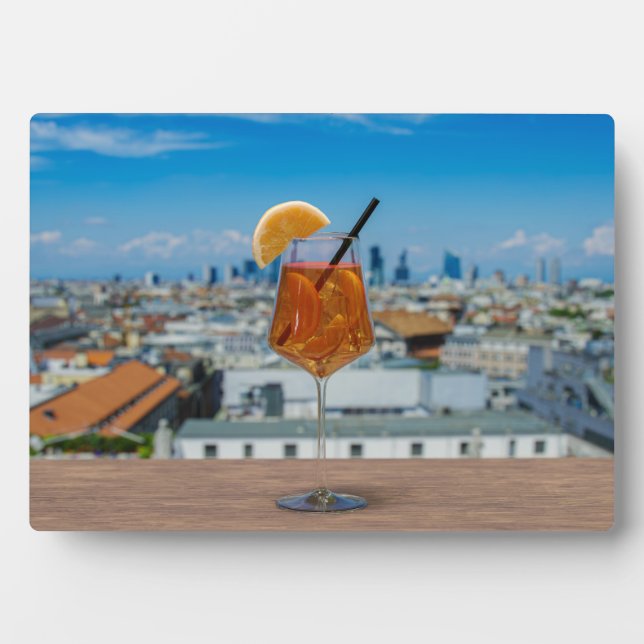 Spritz cocktail on a table with view of Milan Plaque (Front)