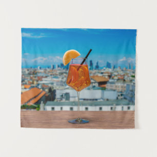 Spritz cocktail on a table with view of Milan Tapestry