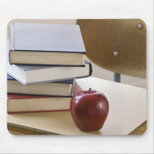 Stack of books, apple, and school desk mouse mat