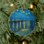 Starry Night Over the Rhône | Vincent van Gogh Ceramic Tree Decoration<br><div class="desc">Starry Night Over the Rhône (1888) by Vincent van Gogh is a mesmerising Post-Impressionist painting that captures a serene nighttime view of the Rhône River in Arles, France. The artwork features a deep blue sky adorned with shimmering golden stars and their reflections on the water. In the foreground, two figures...</div>