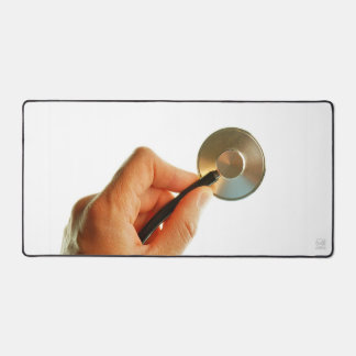 Stethoscope in a hand for a hospital atmosphere. desk mat