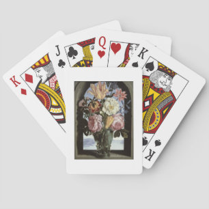 Still life of flowers in a drinking glass playing cards