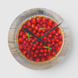 Strawberry cake with mint leaves on a rustic wood round clock