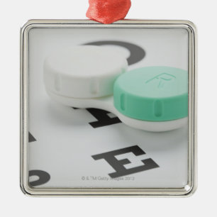 Studio shot of contact lens case on eye chart metal tree decoration