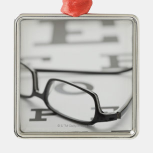 Studio shot of eyeglasses on eye chart metal tree decoration