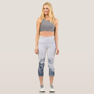 Stunning snowy mountains covered by clouds capri leggings