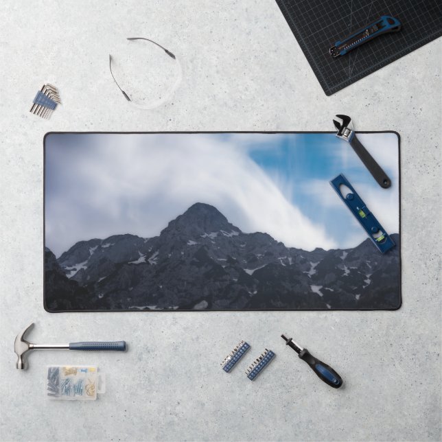 Sun lit green forest beneath the mountains desk mat (Workstation)