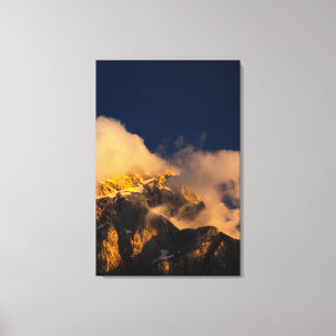Sun lit mountains covered by clouds canvas print