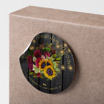 Sunflowers and burgundy roses rustic wood wedding classic round sticker<br><div class="desc">Editable text wedding favour sticker featuring a rustic big beautiful yellow sunflowers and red burgundy roses bouquet and faux gold typography script on a dark brown barn wood background with string lights. Ideal for your summer or autumn fall | elegant rustic country | outdoor backyard vintage traditional themed weddings. Personalise...</div>