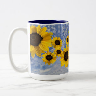 Sunflowers blowing across a blue sky with clouds Two-Tone coffee mug
