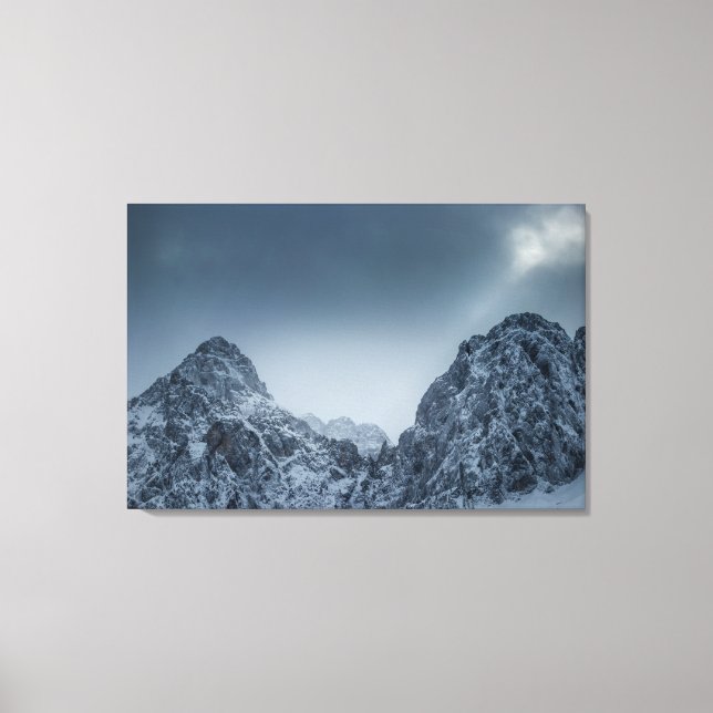 Sunlight and dark clouds over snowy mountains canvas print (Front)