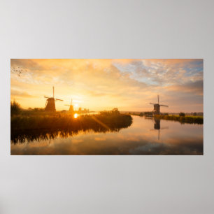 Sunrise over windmills and a river in Holland Poster