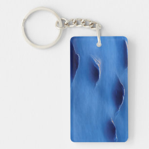 Sunset on rocks protruding through foamy water key ring