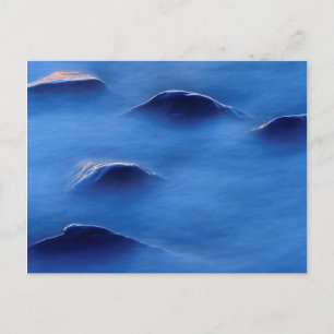 Sunset on rocks protruding through foamy water postcard