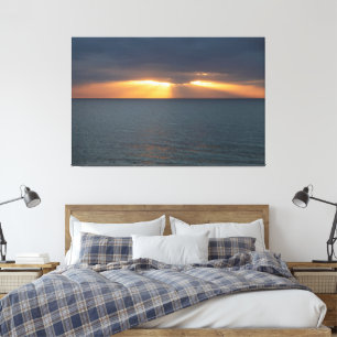 Sunset over the ocean breaking through the clouds canvas print