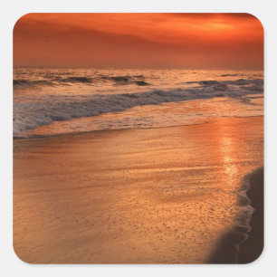 Sunset reflections off clouds and ocean shore square sticker