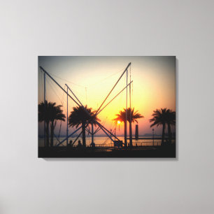 Sunset with palm trees and trampoline canvas print