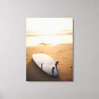 Surfboard laying on beach at sunset