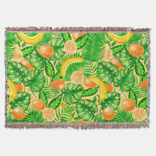 Tangerines, bananas and tropical leaves throw blanket