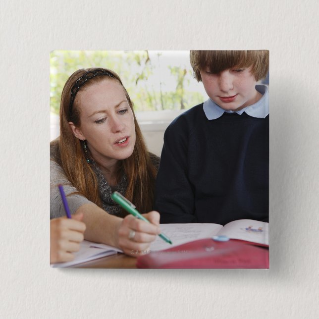 teacher assisting child with work in classroom 15 cm square badge (Front)