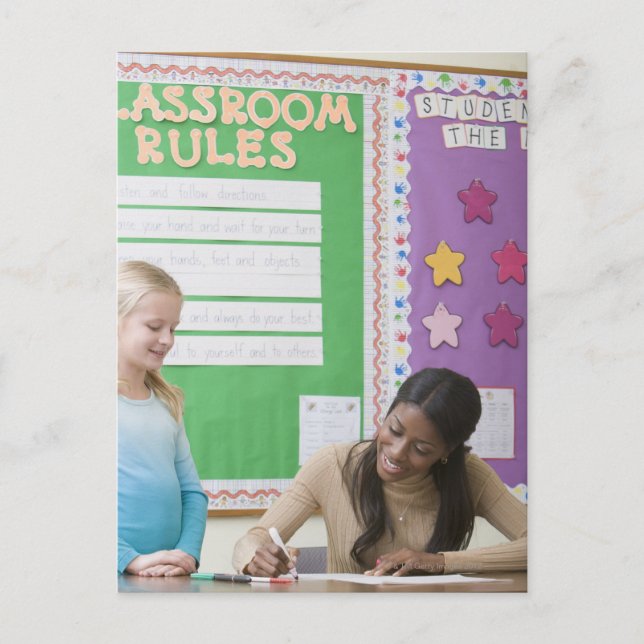 Teacher grading girls paper in classroom postcard (Front)