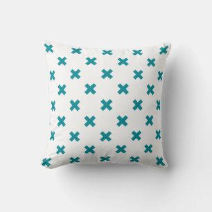 Teal cross stitches on white cushion