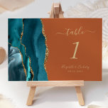 Teal Gold Agate Burnt Orange Wedding Table Number<br><div class="desc">The left-hand edge of this elegant modern wedding table number card features a teal blue watercolor agate border trimmed with faux gold glitter. The customisable text combines gold-coloured handwriting,  italic and copperplate fonts on a burnt orange background.</div>