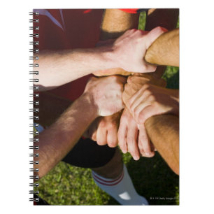 Team with arms-in notebook