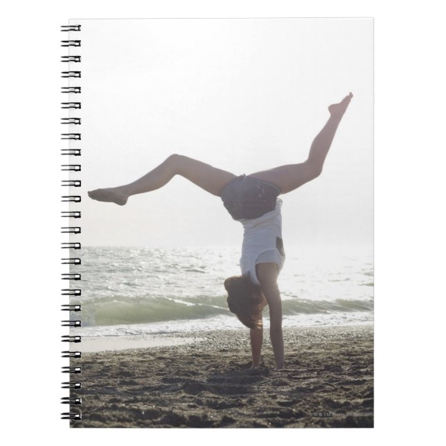 Teenage girl performs gymnastic feat, mum notebook (Front)
