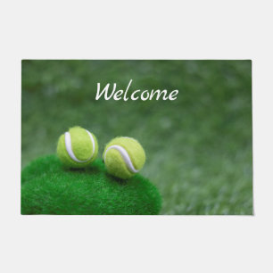 Tennis ball are on green grass doormat